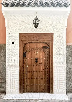 a wooden door in a building with a light above it at Riad Jalma in Marrakech