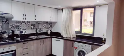 a kitchen with white cabinets and a washer and dryer at Dream Land Duplex for families in Marrakech