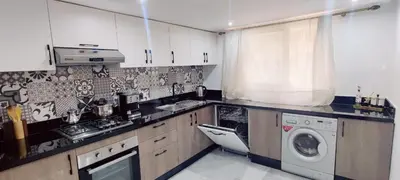 a kitchen with white cabinets and a washer and dryer at Dream Land Duplex for families in Marrakech