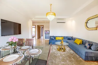 a living room with a blue couch and tables at New! App avec Vue sur Piscine à Noria Golf in Marrakech