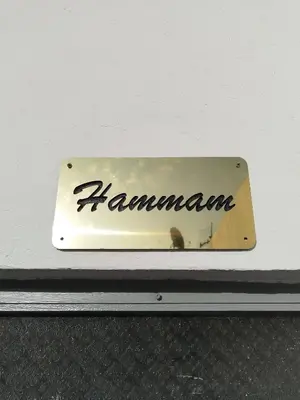 a metal sign that says hamamana on a wall at Riad L'Arganier in Marrakech
