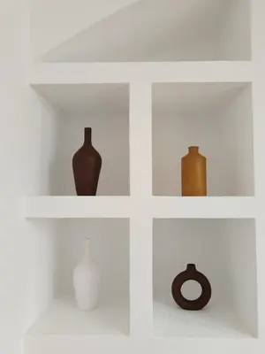 a white shelf with vases and vases on it at Riad L'Arganier in Marrakech