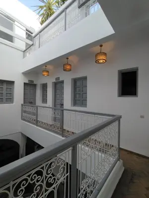 a staircase in a white house with lights at Riad L'Arganier in Marrakech