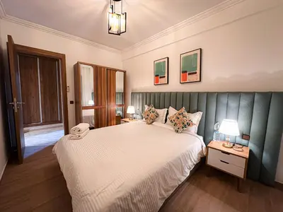 a bedroom with a bed and two tables with lamps at Appartement de Luxe bien équipé in Marrakech