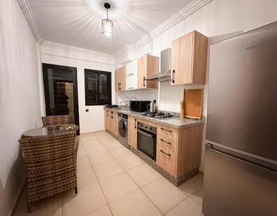 a kitchen with a refrigerator and a counter top at Appartement de Luxe bien équipé in Marrakech