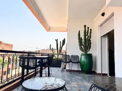 a patio with a table and chairs and a cactus at Appartement sur Majorelle in Marrakech