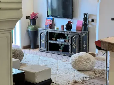 a living room with a tv and a table at Appartement sur Majorelle in Marrakech
