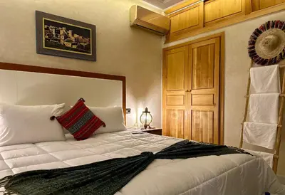 a bedroom with a white bed with a red pillow on it at Riad Tislite & SPA in Marrakech