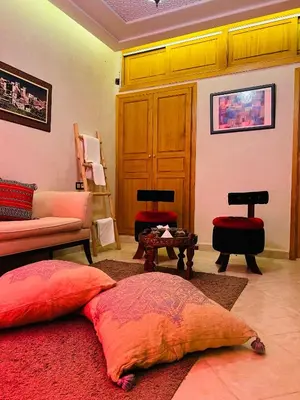 a living room with red pillows on a red rug at Riad Tislite & SPA in Marrakech