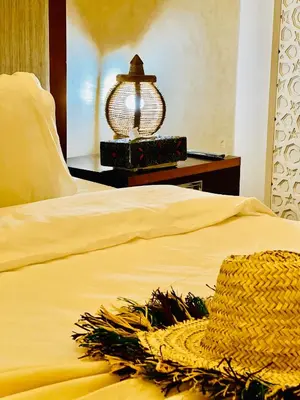 a bed with a lamp and a hat on it at Riad Tislite & SPA in Marrakech