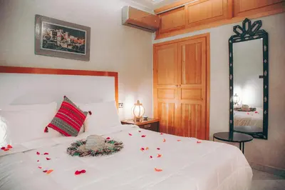 a bedroom with a white bed with flowers on it at Riad Tislite & SPA in Marrakech