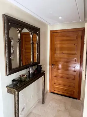 a room with a mirror and a wooden door at Appartement élégant avec vue sur piscine jardin verdoyant et wifi ultra rapide in Marrakech