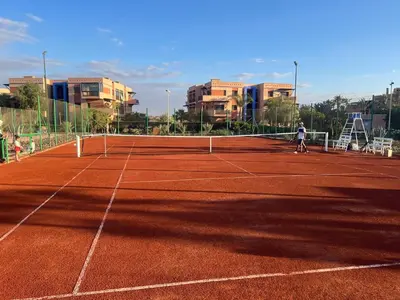 a man standing on a tennis court at Appartement élégant avec vue sur piscine jardin verdoyant et wifi ultra rapide in Marrakech