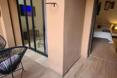 a room with a balcony with a bed and a chair at appartement de luxe gueliz in Marrakech