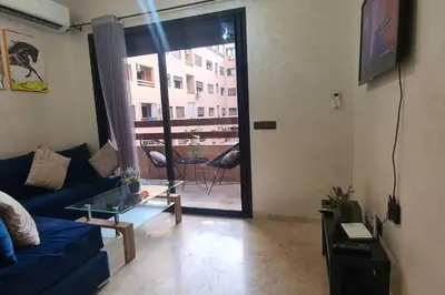 a living room with a blue couch and a sliding glass door at appartement de luxe gueliz in Marrakech
