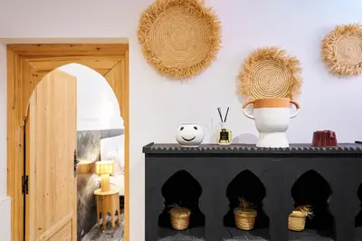 a room with a black cabinet and two wreaths on the wall at Riad Kbala in Marrakech