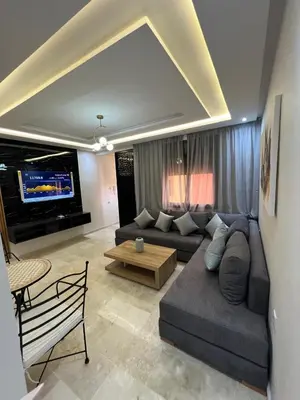 a living room with a couch and a tv at Gueliz Luxe Apartment in Marrakech