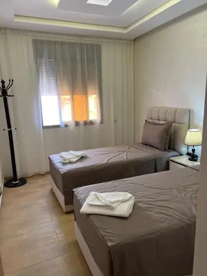 a hotel room with two beds and a window at Gueliz Luxe Apartment in Marrakech