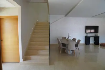 a dining room with a table and a staircase at Villa Home Orient Avec Piscine Privée 3 Chambres in Marrakech