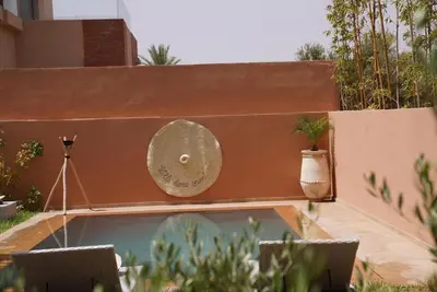 a small swimming pool in a backyard with a vase at Villa Home Orient Avec Piscine Privée 3 Chambres in Marrakech