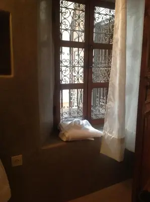 a window with a white curtain and a towel next to it at Riad Dar Lalla Fatna in Marrakech