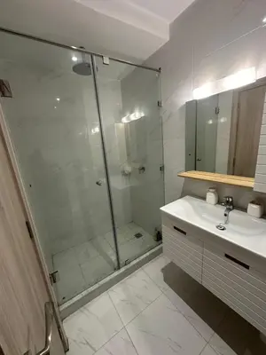 a bathroom with a glass shower and a sink at Appartement avec piscine in Marrakech