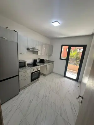 a large kitchen with white tile floors and a window at Appartement avec piscine in Marrakech