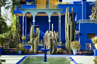 a blue building with a fountain and cactuses in front at Marrakech Reverie Downtown in Marrakech