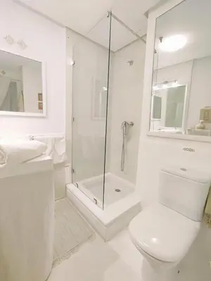 a white bathroom with a shower and a toilet at Studio au coeur de Guéliz in Marrakech
