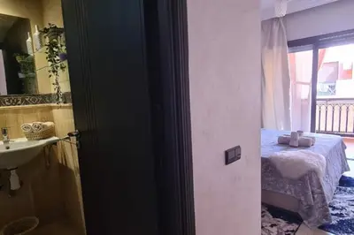 a room with a bed and a sink and a window at appartement 2 chambres en plein centre ville gueliz marrakech in Marrakech