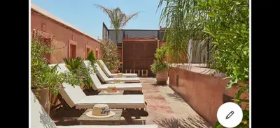 a row of white lounge chairs in a courtyard at Riad Dar one in Marrakech