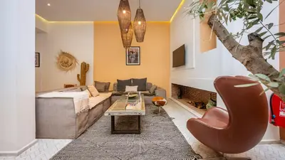 a living room with a couch and a table at Riad Jarco Marrakech, cœur Medina, Rooftop, bassin , Proche Place Jemaa el fna in Marrakech