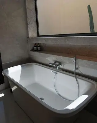 a white bath tub in a bathroom with a mirror at Villa Volubilis - Marrakech in Marrakech