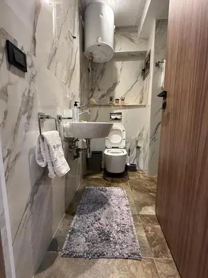 a white bathroom with a sink and a toilet at Élégant Appartement Moderne familiale Marrakech in Marrakech