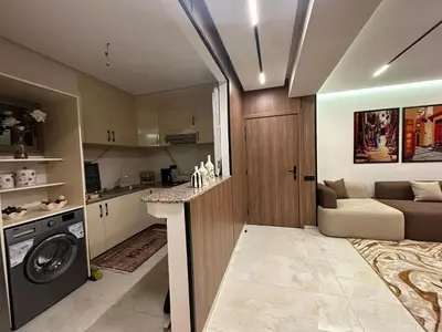 a kitchen and living room with a washing machine in a room at Élégant Appartement Moderne familiale Marrakech in Marrakech