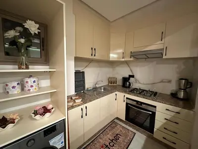 a small kitchen with white cabinets and a sink at Élégant Appartement Moderne familiale Marrakech in Marrakech