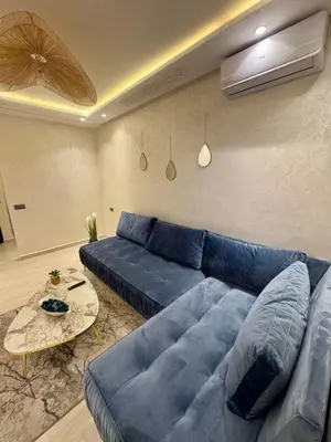 a living room with a blue couch and a table at The Blue Pearl - Fresh & Modern in Marrakech