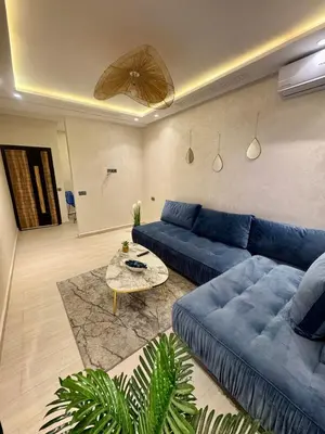 a living room with a blue couch and a table at The Blue Pearl - Fresh & Modern in Marrakech
