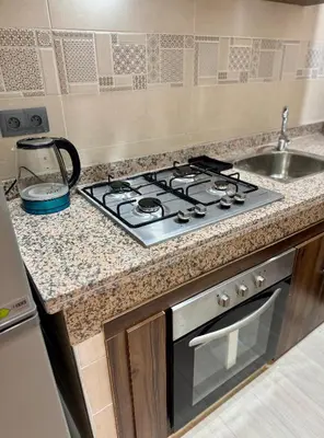 a kitchen counter with a stove and a sink at The Blue Pearl - Fresh & Modern in Marrakech