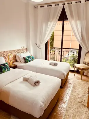 a bedroom with two beds and a window at Maison d'Hôte Angele in Sfiani
