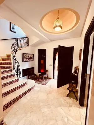a living room with a staircase and a stair case at Maison d'Hôte Angele in Sfiani