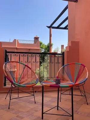 two chairs sitting on a patio next to a fence at Maison d'Hôte Angele in Sfiani