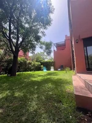 a green yard with a tree and a building at Maison d'Hôte Angele in Sfiani