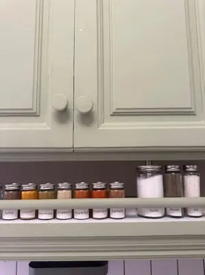 a shelf in a refrigerator filled with jars of spices at Somptueux appartement jardin & piscine - Hivernage in Marrakech