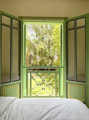 a bedroom with a window with a view of a yard at Somptueux appartement jardin & piscine - Hivernage in Marrakech