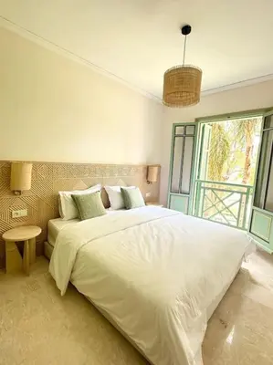 a bedroom with a large white bed and a window at Somptueux appartement jardin & piscine - Hivernage in Marrakech