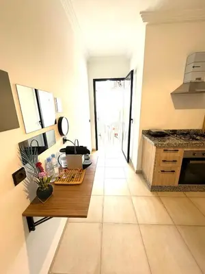 a kitchen with a counter and a table in a room at Appartement au Centre ville Gueliz avec piscine in Marrakech