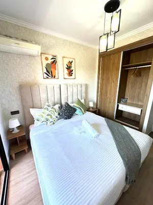 a bedroom with a large bed with blue and white sheets at Appartement au Centre ville Gueliz avec piscine in Marrakech