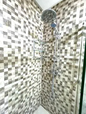a shower in a bathroom with a tiled wall at Appartement au Centre ville Gueliz avec piscine in Marrakech