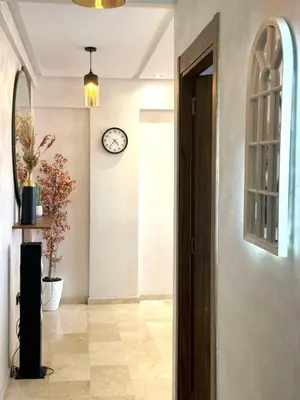 a hallway with a door and a clock on the wall at Appartement au Centre ville Gueliz avec piscine in Marrakech